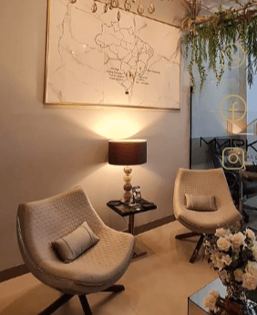 Imagem de uma sala decorada, e com duas poltronas e uma luminária entre elas
