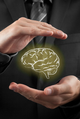 Imagem de cérebro envolto com uma mão humana.